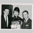 Mary Mon Toy posing with two men holding the album soundtrack for The World of Suzie Wong film (ddr-densho-367-186)