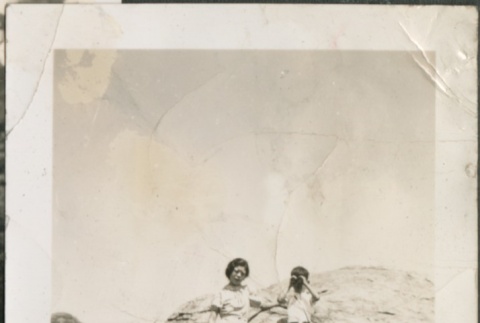 A woman and boy posing near a large boulder (ddr-densho-316-12)