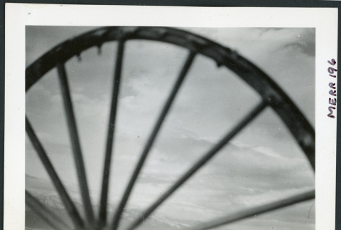 Photograph of distant mountains and sky taken through a wagon wheel in Death Valley (ddr-csujad-47-111)