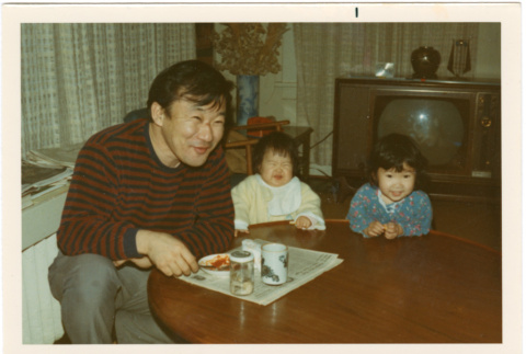 Man sitting at low table with two small children (ddr-densho-430-195)