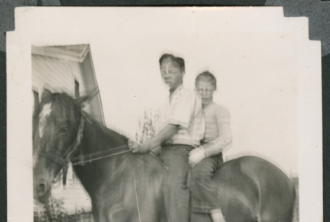 Blurry photon of two people on a horse (ddr-densho-483-343)