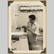 Gary Kikawa working at a counter (ddr-densho-542-521)