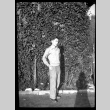 Man standing in front of ivy-covered wall (ddr-densho-475-84)
