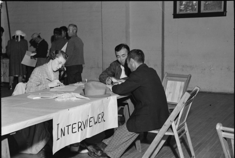 Government worker interviewing father and son (ddr-densho-151-218)