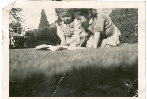 Two young girls reading a book (ddr-densho-430-161)