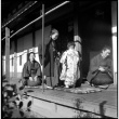 Three women and child seated outside house (ddr-densho-426-310)