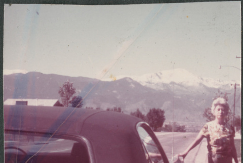 Agnes Sakura standing next to car with ragtop (ddr-densho-523-608)
