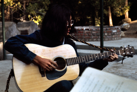 Mike Okagaki playing guitar at morning watch (ddr-densho-336-362)
