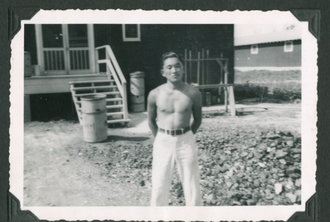 Shirtless man stands outside building (ddr-densho-471-109)