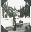 Man standing on road in snow with suitcases (ddr-ajah-2-348)