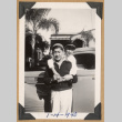 Two people pose by a car (ddr-densho-542-209)