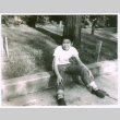 Frank Nishioka sitting on curb (ddr-densho-292-62)