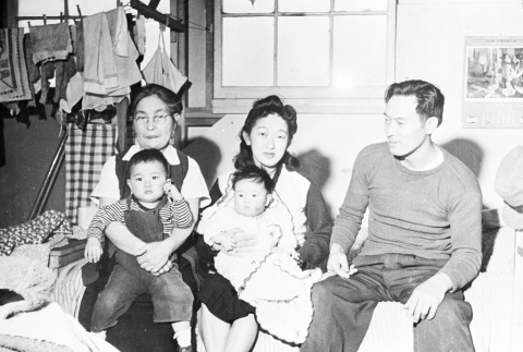 Japanese American family inside barracks (ddr-densho-39-28)