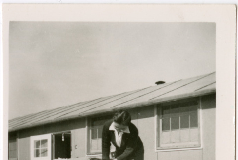 Sally Domoto walking with toddler outside barracks (ddr-densho-329-1334)