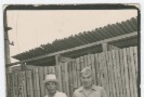 (Photograph) - Image of two men standing in front of bamboo fence (PDF) (ddr-densho-332-25-mezzanine-88218b6322)