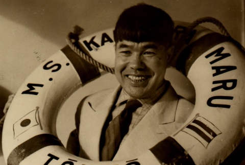 Shiro Otsuji posing with an NYK Line ring buoy (ddr-njpa-4-1698)