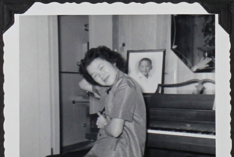 A girl sitting on a piano bench (ddr-densho-300-512)