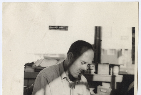 Man writing at a desk (ddr-densho-542-803)