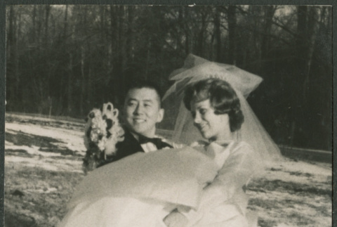 Black and white photo of groom carrying bride (ddr-densho-523-384)