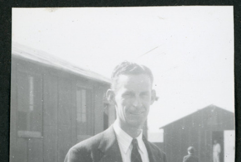 Photograph of Clyde Simpson standing in front of barracks (ddr-csujad-47-169)