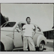 Man standing in front of a car (ddr-densho-321-1232)