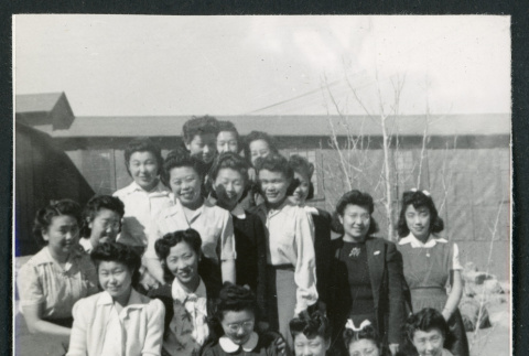 Photograph of a group of people posing in front of the Manzanar hospital (ddr-csujad-47-208)