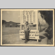 Man standing by sign by fence line (ddr-densho-466-44)