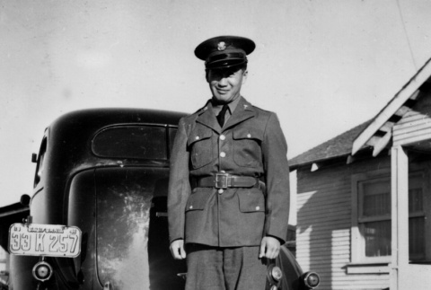 Man in uniform standing by car (ddr-ajah-2-758)