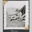 Man sitting outside small tent, eating (ddr-densho-434-82)