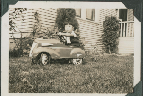Boy in toy car (ddr-densho-355-484)