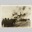 Soldiers pushing carts past a burning house (ddr-njpa-13-907)