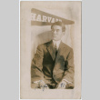 Photo of man in front of Harvard pennant (ddr-densho-355-119)