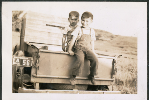 Photo of two children in a pickup truck bed (ddr-densho-483-348)