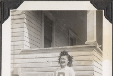 Woman in letter sweater outside house (ddr-densho-466-210)