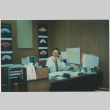 Man seated at desk in office (ddr-densho-426-1305)