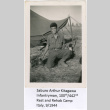 Saburo Arthur Kitagawa kneeling outside tent (ddr-densho-539-23)