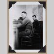 Two men sit at a desk (ddr-densho-404-376)