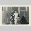 Teacher standing with two students (ddr-manz-7-49)