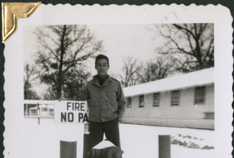 Man standing by fire hydrant with sign (ddr-densho-434-299)