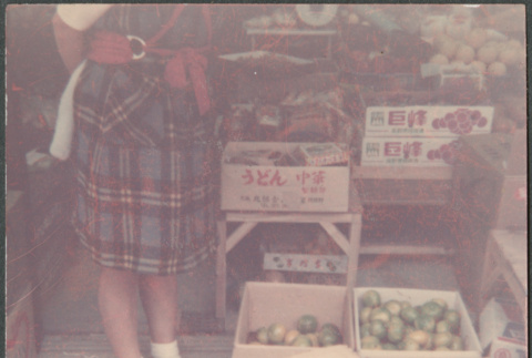 Woman standing by boxes of vegetables and fruits (ddr-densho-523-569)