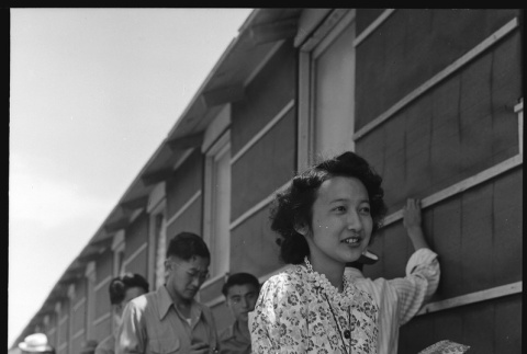 Japanese Americans standing in shade of barracks (ddr-densho-151-282)