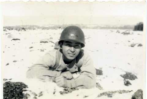 Soldier laying in a field (ddr-densho-22-366)