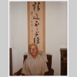 Man sitting in front of Japanese scroll hanging (ddr-densho-501-50)