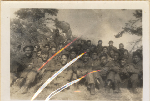 Large group of 33 soldiers sitting on hillside (ddr-densho-466-241)