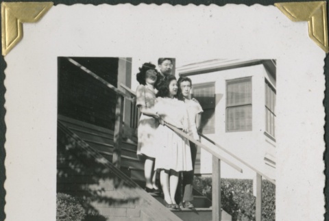 Four people standing on steps (ddr-densho-321-186)