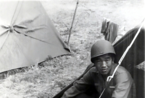 Hisashi Jack Mukumoto sitting outside tent (ddr-densho-474-238)