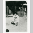 Gloria Kubota and small child outside barracks (ddr-densho-122-643)