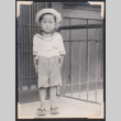 Boy in sailor suit with hat in front of building (ddr-densho-468-485)