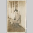 A man seated on a stool wearing a United States Navy hat (ddr-densho-316-19)