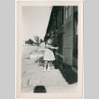 Girl pointing to woman in doorway of barracks (ddr-densho-329-1343)